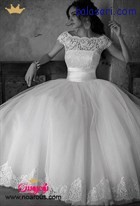 لباس عروس پفی با دامنی ساده که با نمونه تورهای بالاتنه تزئین شده است